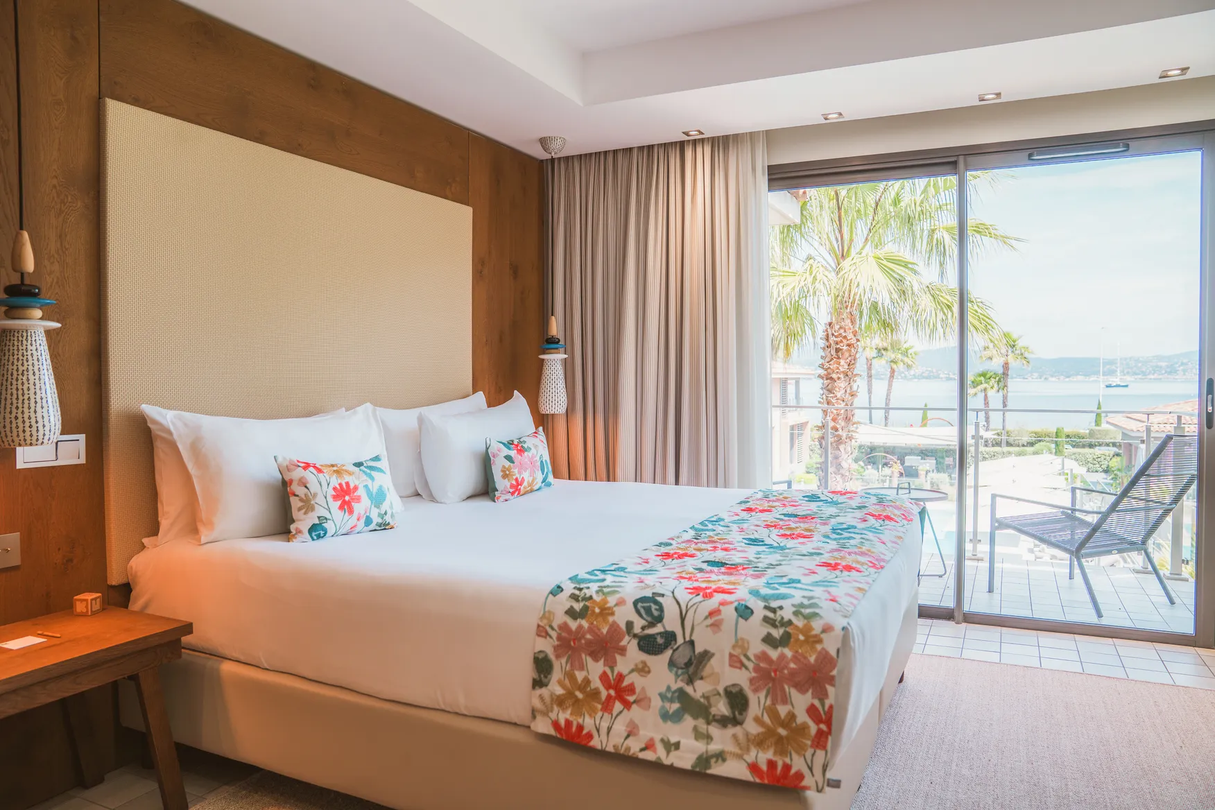 Chambre de luxe avec terrasse privée à l'Hôtel Kube Saint-Tropez : vue sur palmier et design méditerranéen chaleureux.